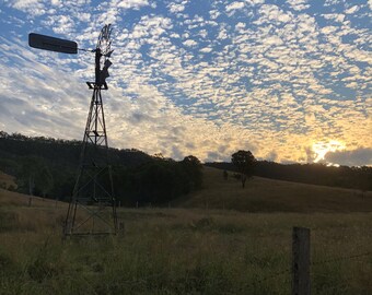 Sunset over the windmill at the end of a long day, with a beautiful sky in the background