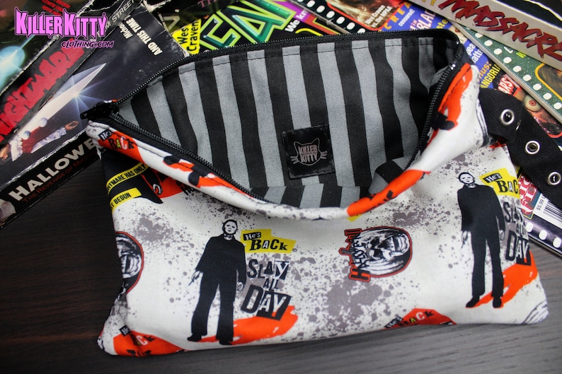 Custom-made Halloween, Michael Myers pouch. All over Michael Myers print with striped lining, zipper closure and grommet strap on the side. Perfect for your phone, keys and makeup!
