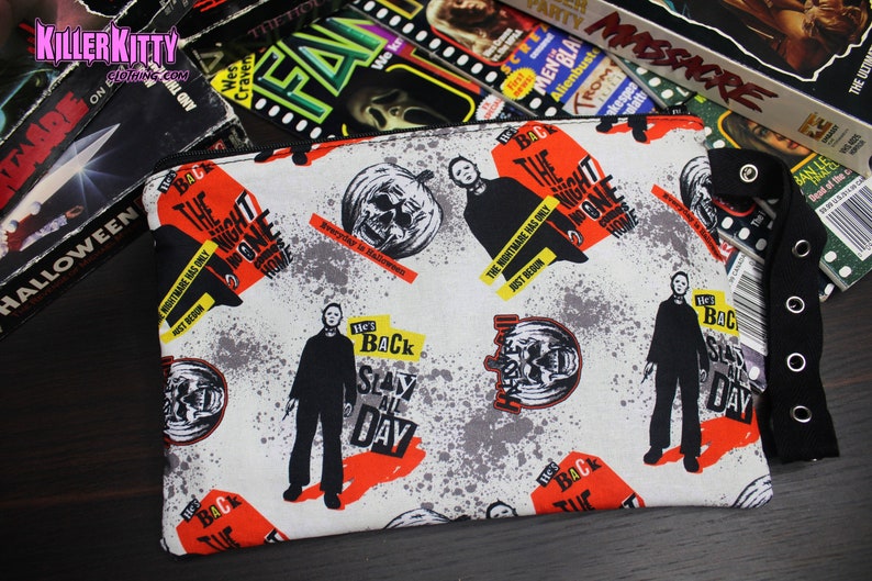 Custom-made Halloween, Michael Myers pouch. All over Michael Myers print with striped lining, zipper closure and grommet strap on the side. Perfect for your phone, keys and makeup!