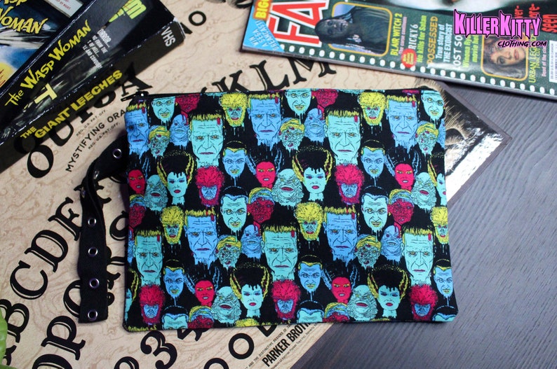 Custom-made Universal Horror Monsters pouch. All over print of The Bride of Frankenstein, Frankenstein, Dracula, Wolfman, The Mummy and Creature from the Black Lagoon. Polka dot lining, zipper closure and grommet strap on the side.