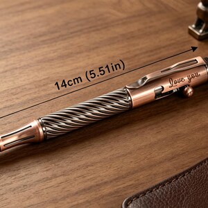 May include: A copper-toned metal ballpoint pen featuring a twisted, textured grip section and a smooth barrel with a pocket clip. The pen is engraved with the text "Love you" and measures 5.51 inches in length as indicated by the visible measurement.