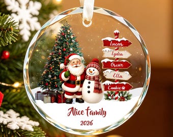 May include: A round, clear glass Christmas ornament featuring a printed scene of Santa Claus and a snowman standing next to a decorated tree. A signpost displays the names Lucas, Lydia, Oscar, Ella, and Cookie. Text reads Alice family 2026.