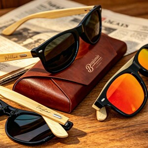 May include: Three pairs of sunglasses with black frames and light-colored wooden temples. One pair has orange reflective lenses, while two have dark lenses. The temples are engraved with the names Willow, Taylor, and Benjamin on a brown case.