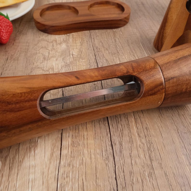 May include: A wooden pepper mill with a clear glass window to view the peppercorns inside. The mill has a stainless steel grinding mechanism.