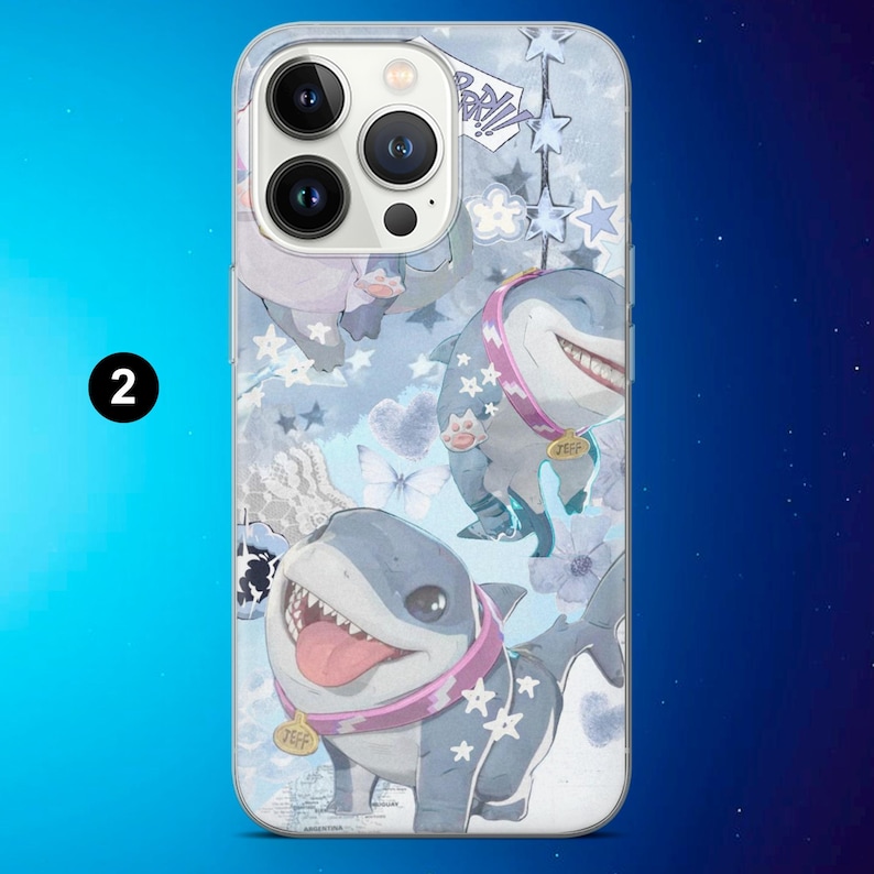 May include: A phone case featuring a whimsical design with cartoon sharks in a light blue background. The sharks have pink collars and are surrounded by stars, clouds, and floral elements. The case has a glossy finish.