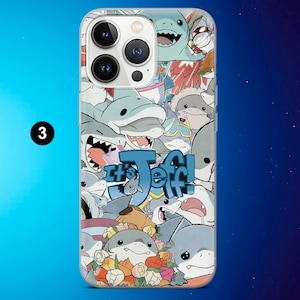 May include: A clear phone case featuring a collage of cartoon sharks in various poses and colors. The phrase "It's Jeff!" is displayed in blue, stylized text. The case has a glossy finish and is designed for a smartphone.