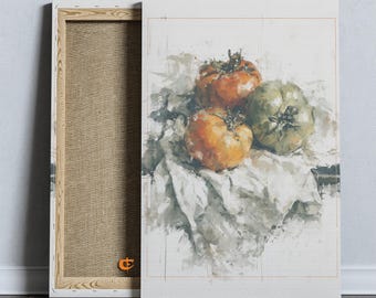 Può includere: Una stampa su tela raffigurante un dipinto ad acquerello di tre pomodori, due arancioni e uno verde, appoggiati su un panno bianco. L'opera è montata su una cornice in legno con un piccolo logo arancione visibile in basso a sinistra.