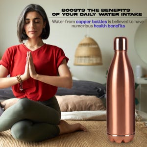 Puede incluir: Una botella de agua de color cobre con un cuerpo redondeado y una base y tapa de color plateado. La botella est&aacute; al lado de una persona con una camisa roja y pantalones verdes, meditando. El texto en la imagen dice: "BOOSTS THE BENEFITS OF YOUR DAILY WATER INTAKE".