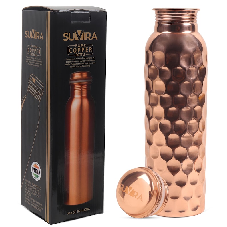 Puede incluir: Una botella de agua de cobre con una superficie texturizada y con hoyuelos, una tapa a juego y una caja negra. La caja presenta el texto "SUVIRA PURE COPPER BOTTLE" y una imagen de la botella. La botella est&aacute; hecha en India.