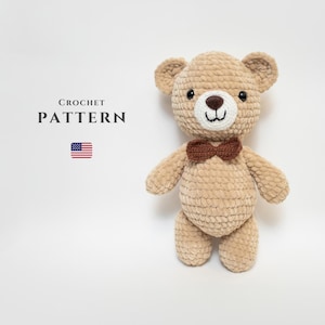 May include: Crochet pattern for a beige teddy bear with a brown bow tie. The pattern is available for download.
