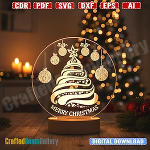 May include: A clear acrylic Christmas tree night light with a wooden base. The tree design is etched with hanging baubles and a star, with the words "Merry Christmas" below. The background features a Christmas tree with lights.
