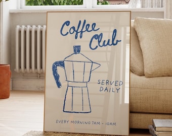 May include: A framed poster with the words "Coffee Club" and a blue illustration of a coffee maker. The poster is propped up on a rug in a living room with a sofa, wooden chair, and potted plant.