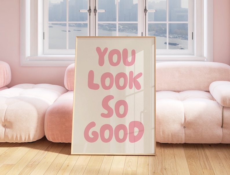May include: A framed print with a pink background and the text "YOU LOOK SO GOOD" in large, pink, bubble letters.