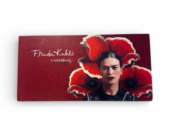 May include: A rectangular makeup palette featuring a portrait of Frida Kahlo with red poppies. The palette has a red background with the words "Frida Kahlo" and "by ULTA Beauty" in white script.