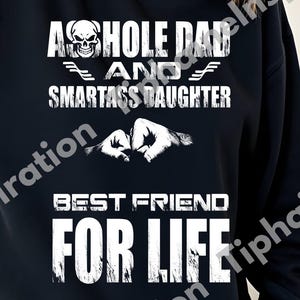 May include: Black sweatshirt with white text that reads "ASSHOLE DAD AND SMARTASS DAUGHTER BEST FRIEND FOR LIFE". The design includes a skull, wings, and clasped hands. The SVG and PNG file icons are in the bottom right corner.