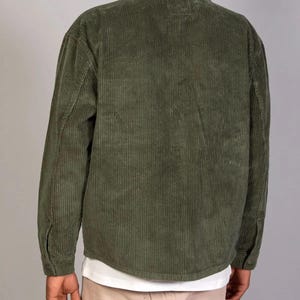 May include: A green corduroy shirt with a button-up front and long sleeves.