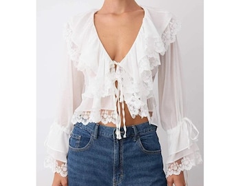Witte en zwarte kanten blouse met ruches: doorschijnende romantische top met lange mouwen