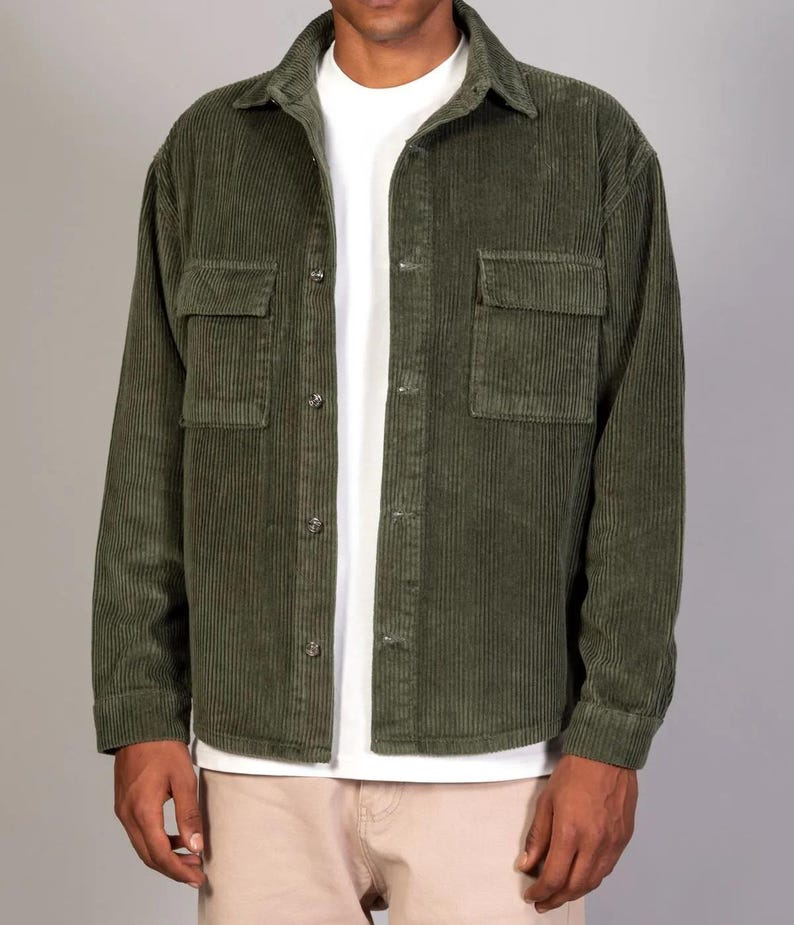 May include: A green corduroy shirt with a button-up front and two large pockets. The shirt has a relaxed fit and long sleeves.