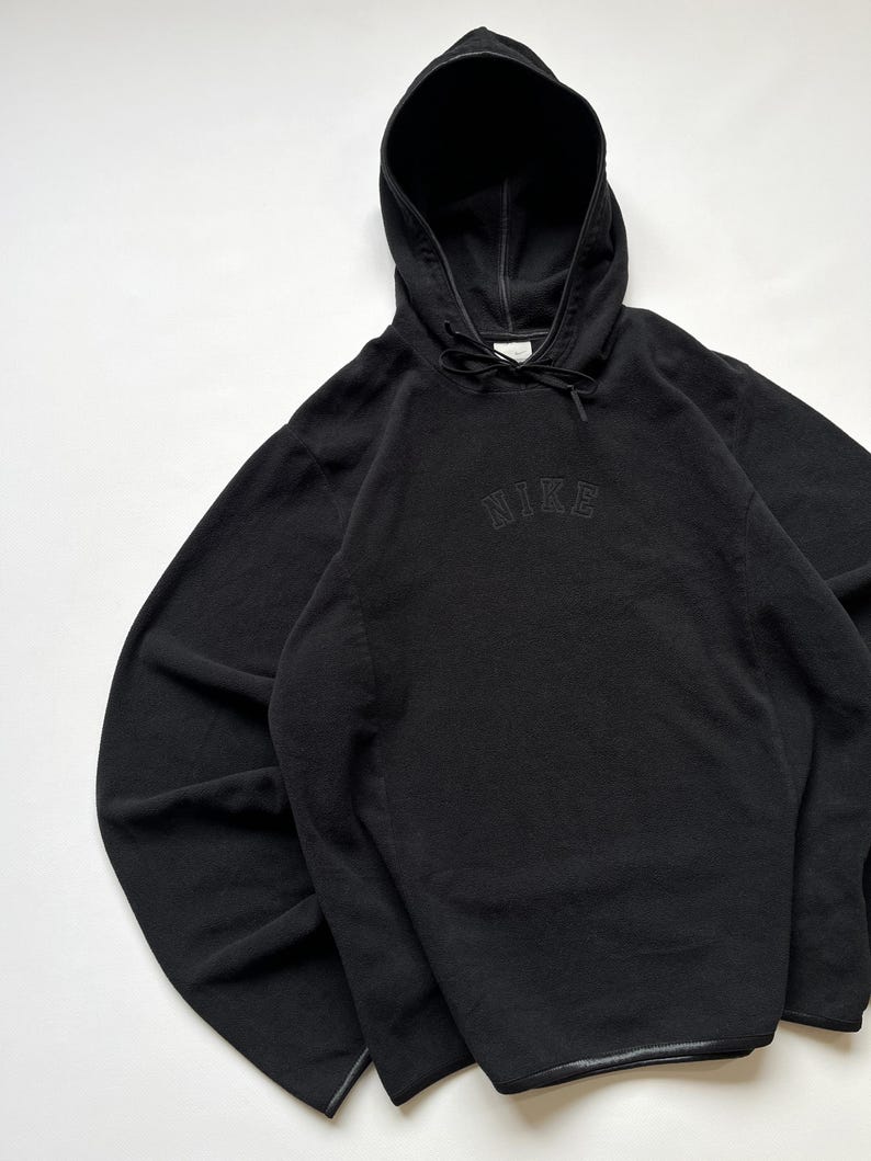 Puede incluir: Sudadera con capucha Nike negra con capucha con cord&oacute;n y el logotipo de Nike bordado en el pecho. La sudadera con capucha est&aacute; hecha de un material suave y texturizado y tiene un ajuste relajado. Las mangas son largas y el dobladillo es recto.