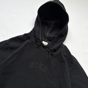 Puede incluir: Sudadera con capucha Nike negra con cord&oacute;n. El logotipo de Nike est&aacute; bordado en negro a trav&eacute;s del pecho. La sudadera con capucha est&aacute; hecha de un material suave y texturizado.