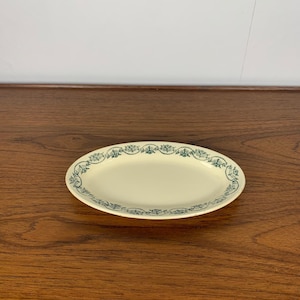 Peut inclure: Un plat de service ovale blanc avec une bordure florale verte.
