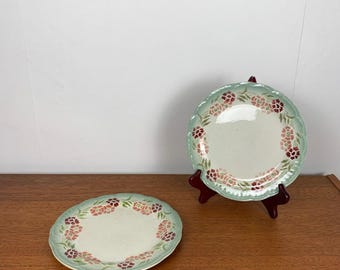 May include: Two vintage floral patterned plates with a green and white border. The plates have a white center and a pink and red floral design.
