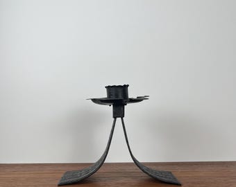 以下が含まれることがあります： ユニークなデザインの黒い金属製のキャンドルホルダー。キャンドルホルダーは、テクスチャパターンを持つ円形のベースと、キャンドルカップを支える中央のステムを備えています。 全体の高さは約15cmです。