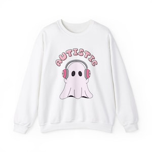 May include: White sweatshirt with a pink ghost wearing headphones and the word "AUTISTIC" in pink letters.