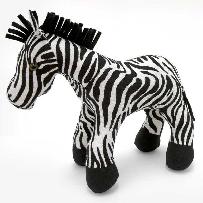 May include: A black and white striped stuffed zebra toy. The zebra has a black mane and a black tail. The zebra is standing on a white background.