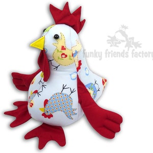 May include: A plush toy chicken with red wings and a red comb. The chicken is made of white fabric with a blue and white floral pattern and a yellow beak. The chicken is sitting on a white background.