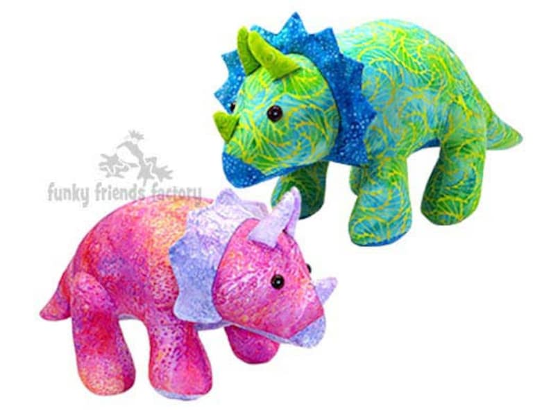 May include: Two plush toy triceratops dinosaurs. One is pink and purple with a green and blue pattern. The other is green and blue with a yellow and green pattern.