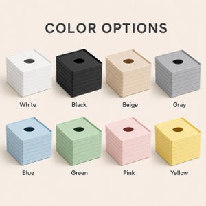 May include: A display of eight stacks of square coasters, each with a central circular cutout. The text COLOR OPTIONS appears at the top. The stacks are labeled White, Black, Beige, Gray, Blue, Green, Pink, and Yellow, corresponding to their colors.