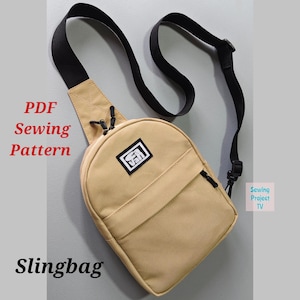 May include: Tan sling bag with a black strap and zipper. The bag has a small square patch with a logo. Text on the image reads "PDF Sewing Pattern" and "Slingbag".