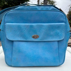 Könnte beinhalten: Eine vintage blaue Lederschultertasche mit einem silbernen Verschluss. Die Tasche hat eine Klappe auf der Vorderseite.
