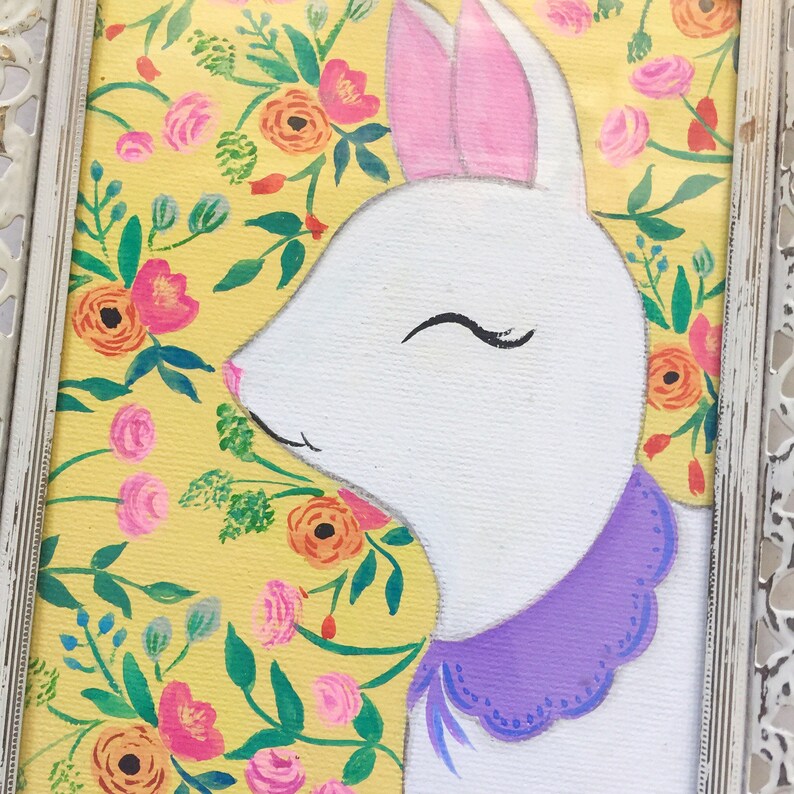 May include: A white rabbit with pink ears and a purple collar with a scalloped edge is painted on a yellow background with a floral pattern.