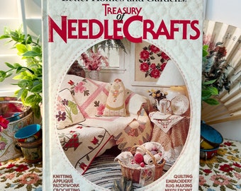 May include: A vintage book titled "Better Homes and Gardens Treasury of Needlecrafts" with a detailed illustration of needlecraft projects. The cover features a cozy interior scene with floral patterns, a basket of yarn, and the listed crafts: knitting, applique, patchwork, crocheting, quilting, embroidery, rug making, and needlepoint.