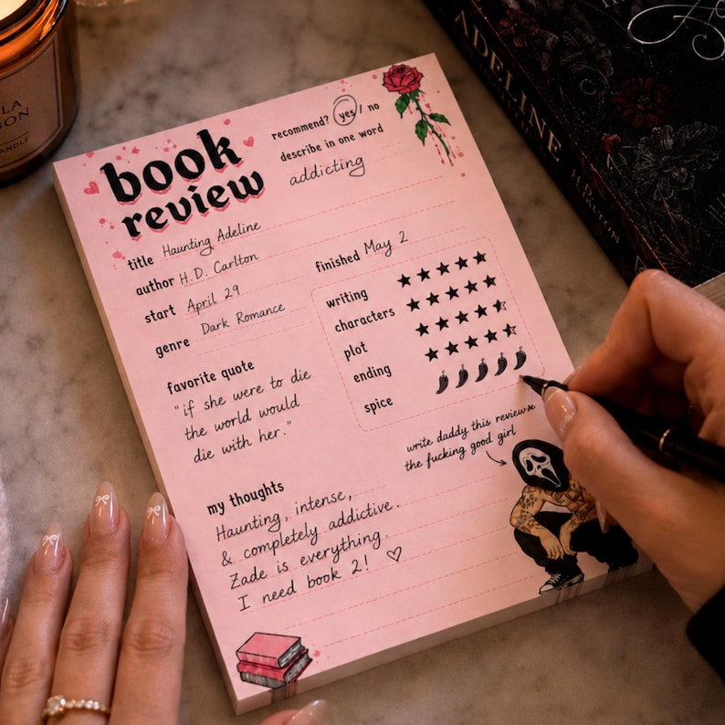 K&ouml;nnte beinhalten: Ein rosa Notizblock f&uuml;r eine Buchrezension mit dem Titel "book review" in schwarzer Schrift. Der Notizblock enth&auml;lt Abschnitte f&uuml;r Titel, Autor, Startdatum, Genre und Lieblingszitat. Eine Hand schreibt mit einem schwarzen Stift auf den Notizblock.
