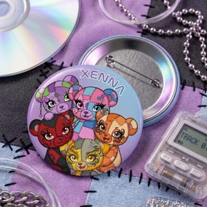 May include: A circular pinback button featuring a colorful illustration of five stylized teddy bears with patchwork patterns and large eyes. The text XENNA is printed in white at the top. The button has a metallic back with a pin mechanism.