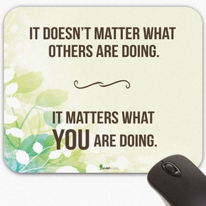 May include: A motivational quote mousepad with a green and blue watercolor background. The quote reads: "It doesn't matter what others are doing. It matters what you are doing."