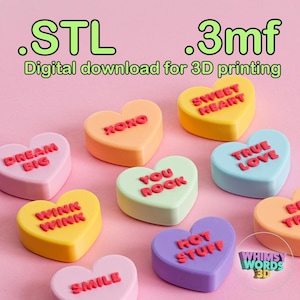 May include: A set of ten 3D printed heart-shaped candy conversation hearts with various phrases printed on them, including "Dream Big", "XOXO", "Sweet Heart", "You Rock", "True Love", "Wink Wink", "Hot Stuff", "Smile", and "Be True". The hearts are arranged on a pink background. The text "Whimsy Words 3D" is visible in the lower right corner of the image.