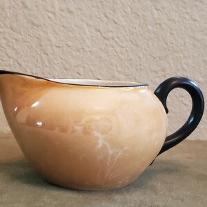 Opalescent Brown Creamer With Black Handle