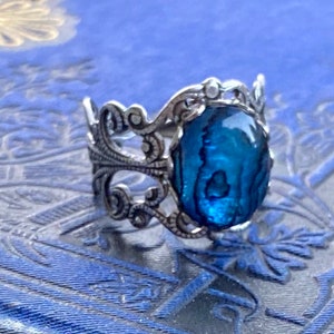 Antiqued silver filigree adjustable ring with blue shell.