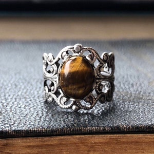 Antiqued silver filigree adjustable rings in vintage style with a tiger's eye cabochon set on a bezel.