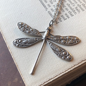 Floral motif dragonfly pendant necklace in antiqued silver.