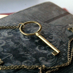 Antiqued brass oval skeleton key pendant necklace in vintage style.