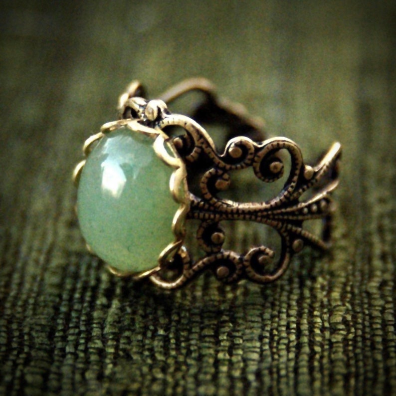 Sage green aventurine stone mineral cabochon on and antiqued brass adjustable filigree ring in vintage=style.