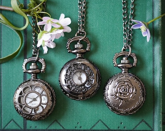 Peut inclure: Trois montres de poche de style antique avec des motifs ornés sont suspendues à des chaînes argentées. Les cadrans des montres sont blancs avec des chiffres et des aiguilles noirs. Une montre présente un motif de rose, une autre a un cadran ouvert et la troisième un motif floral décoratif.