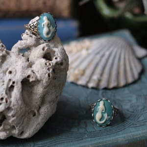 Antiqued silver and brass adjustable vintage style ring with a blue and cream mermaid cameo.