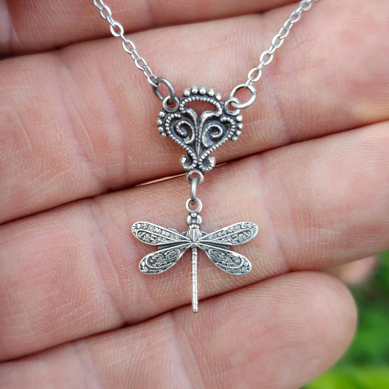 Antiqued silver filigree small dragonfly necklace in vintage syle on a chain with a connector.