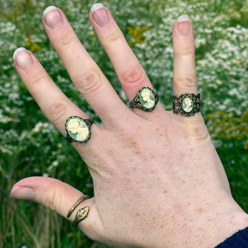Antiqued brass adjustable filigree ring in vintage-style with a green and cream small lady cameo set on a bezel. Set of three styles.